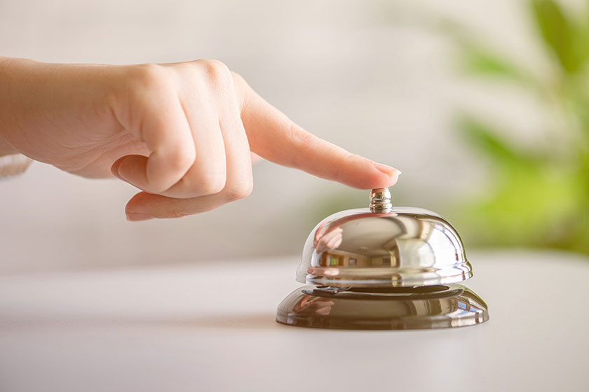 hand-guest-ringing-silver-bell-reception-desk-copy-space-hotel